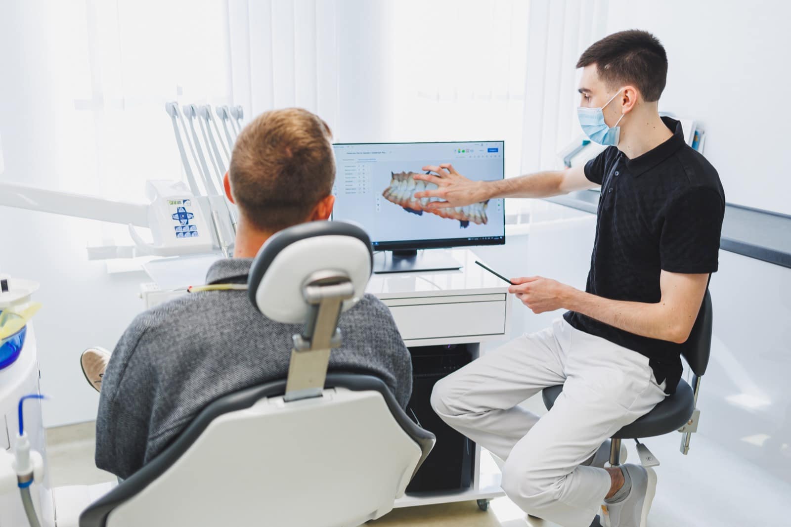 Dentista de Arcodental explicando a un paciente su diagnóstico 3D en la clínica de Getafe